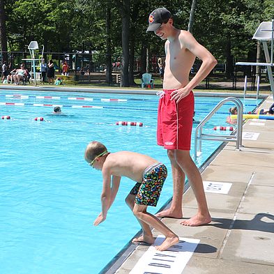 kid learning to dive into pool