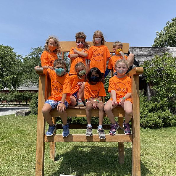 children sitting in a giant chair at camp
