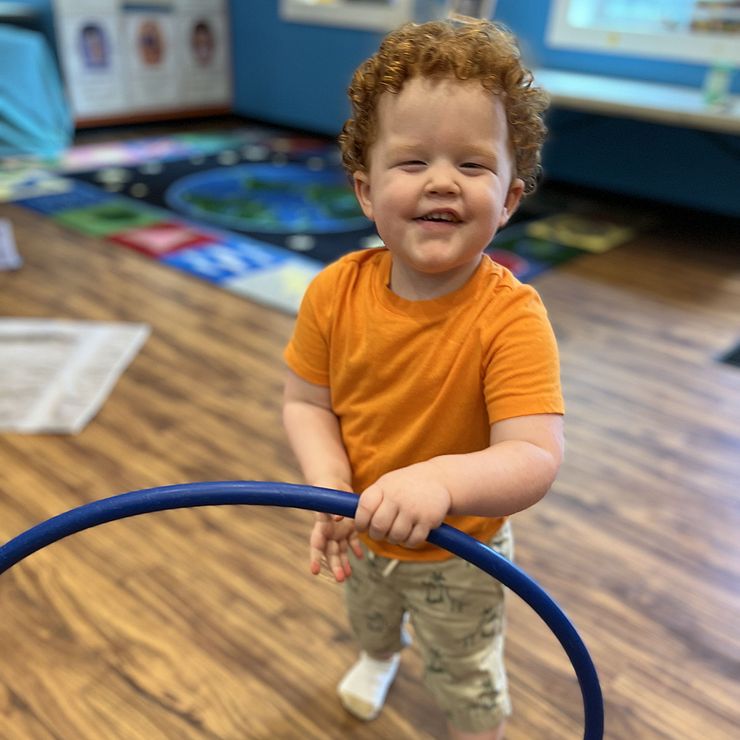 toddler playing with hula hoop