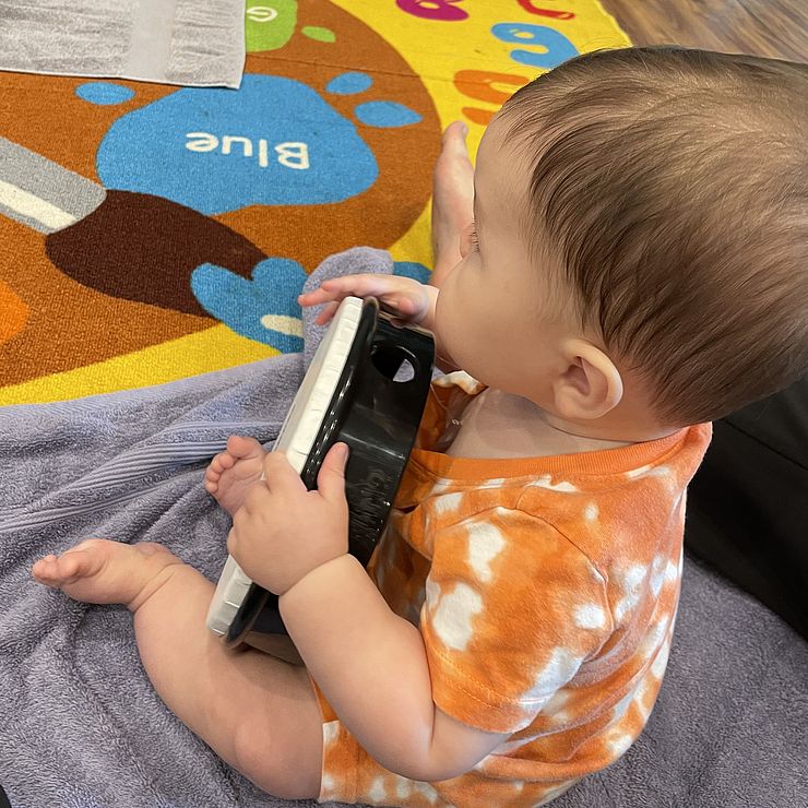 infant playing with tambourine 